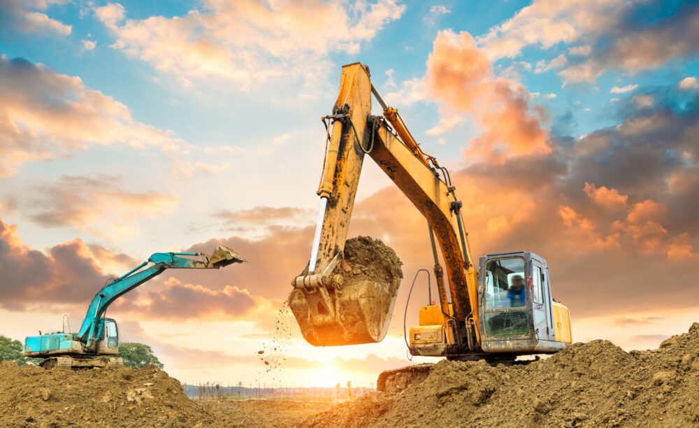 excavator in construction site on sunset sky background excavator in construction site on sunset sky background